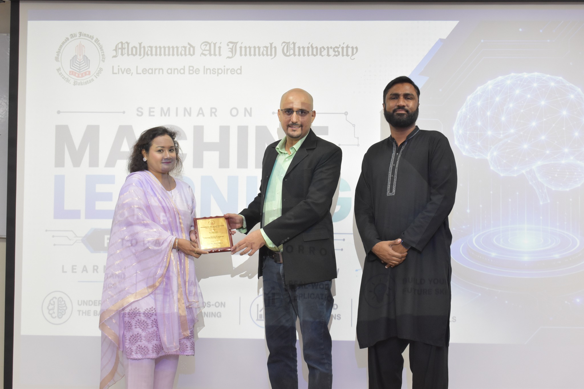 Haris Jafri receiving a commemorative plaque at the Seminar on Machine Learning at Mohammad Ali Jinnah University